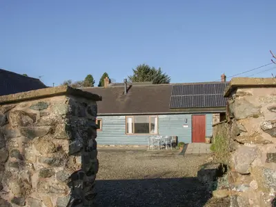 an external view of a house with a stone wall at Cranberry Cottage in Shrewsbury