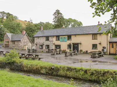 a pub with picnic tables in front of it at Cranberry Cottage in Shrewsbury