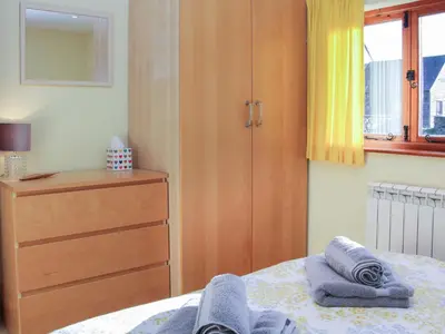 a bedroom with a dresser and towels on a bed at Cranberry Cottage in Shrewsbury