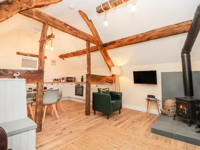 a living room with a fireplace and a stove at Stabl, Plas Moelfre Hall Barns in Oswestry