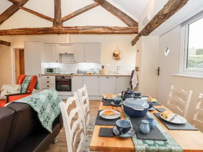 a kitchen and dining room with a table and chairs at Cut Moch, Plas Moelfre Hall Barns in Oswestry