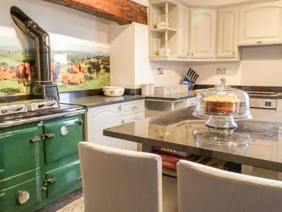 a kitchen with a table with a cake on it at Squires Rest in Welshpool