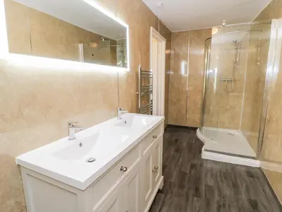 a bathroom with a white sink and a shower at Squires Rest in Welshpool