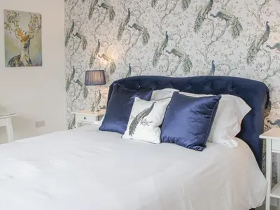 a bed with a blue headboard in a bedroom at Hillside Lodge in Ludlow