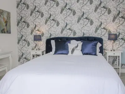 a bedroom with a white bed with blue pillows at Hillside Lodge in Ludlow