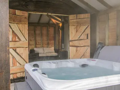 a large bath tub in a room with wooden walls at Hillside Lodge in Ludlow