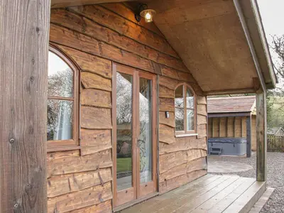 a wooden cabin with large windows on the outside at Hillside Lodge in Ludlow