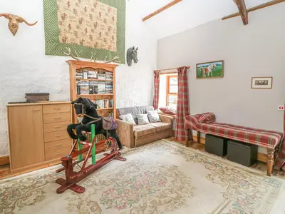 a living room with a chair and a couch at Felin Iago in Aberystwyth