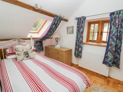 a bedroom with a bed and a window at Felin Iago in Aberystwyth