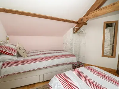 a bedroom with two beds and a window at Felin Iago in Aberystwyth