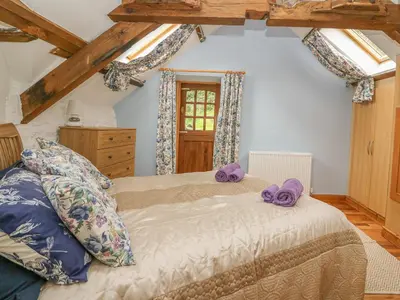 a bedroom with a bed with purple towels on it at Felin Iago in Aberystwyth