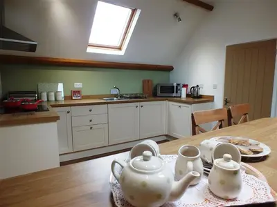 a kitchen with two tea sets on a table at Pond Cottage in New Quay