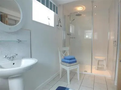 a white bathroom with a sink and a shower at Pond Cottage in New Quay
