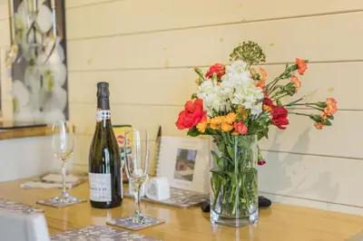 a vase of flowers and a bottle of wine on a table at Stiperstones Pod in Shrewsbury