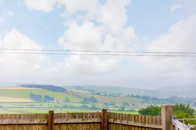 a wooden fence with a view of a green field at Stiperstones Pod in Shrewsbury