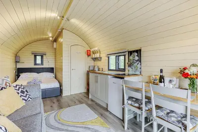 a room with a bed and a kitchen with a counter at Stiperstones Pod in Shrewsbury