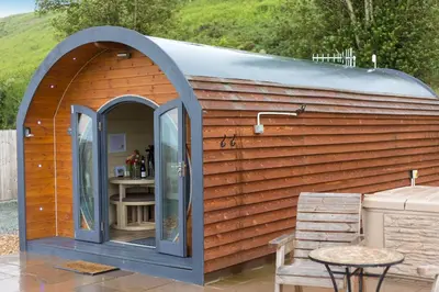 a small shed with a table and a chair at Corndon Pod in Shrewsbury
