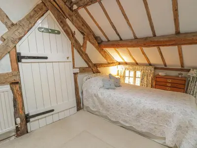 a bedroom with a bed in a attic at Lower Dolgenau- The Cottage in Caersws