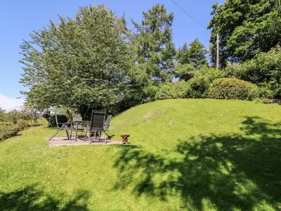 a table and chairs sitting on top of a grassy hill at Lower Dolgenau- The Cottage in Caersws