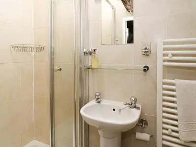 a bathroom with a sink and a shower at Lower Dolgenau- The Cottage in Caersws