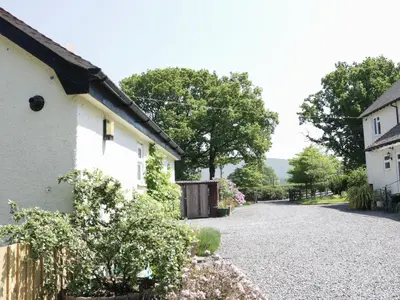 a house with a gravel driveway next to a house at The Little Dingle in Church Stretton