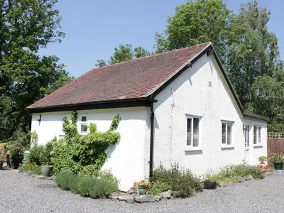 an old white building with a brown roof at The Little Dingle in Church Stretton