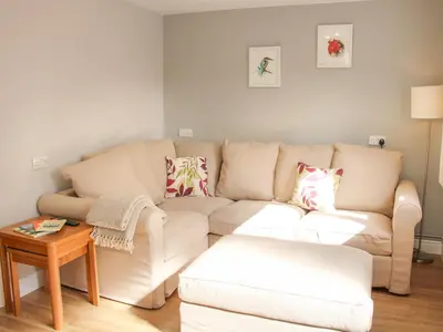 a living room with a couch and a table at The Little Dingle in Church Stretton