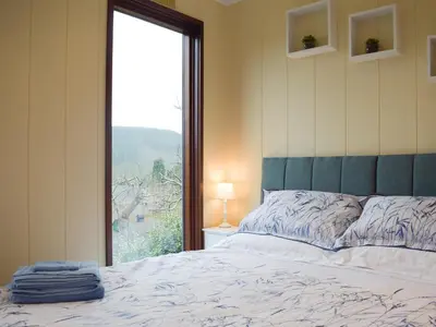a bedroom with a bed and a large window at The Wooden Lodge in Byton