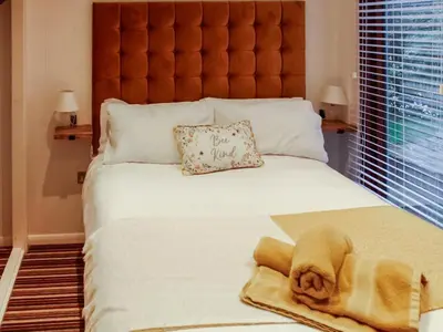 a large bed with a stuffed animal laying on it at The Wooden Lodge in Byton