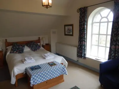 a bedroom with a bed and a window at Alltybrain Farm Cottages in Brecon
