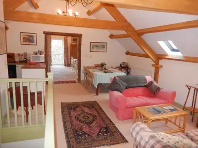 a living room with a red couch and a table at Alltybrain Farm Cottages in Brecon