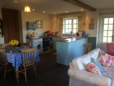 a kitchen and living room with a couch and a table at Alltybrain Farm Cottages in Brecon