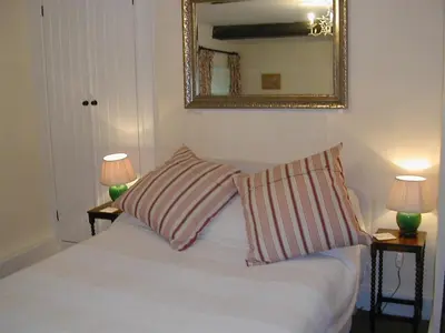 a bedroom with a bed with two pillows and a mirror at Alltybrain Farm Cottages in Brecon