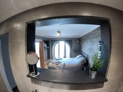 a bedroom with a bed and a mirror on the wall at 46 Y Lanfa in Aberystwyth