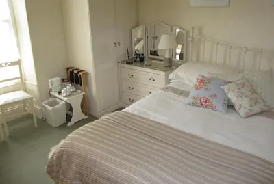 a bedroom with a white bed with pillows and a dresser at Beechwood House in New Quay