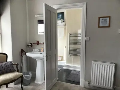 a bathroom with a sink and a toilet and a mirror at Beechwood House in New Quay