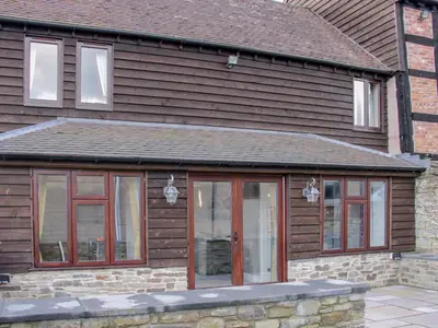 a house with glass doors on the side of it at Alders View Coach House in Craven Arms