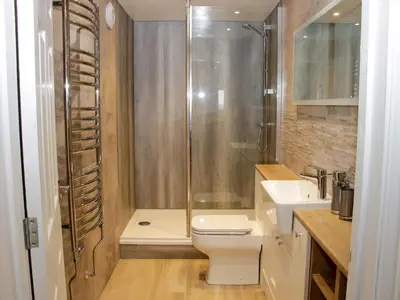 a bathroom with a shower and a toilet and a sink at Alders View Coach House in Craven Arms