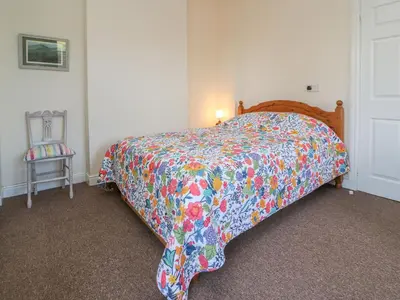 a bed with a colorful comforter in a bedroom at Garden View in Kington