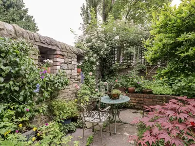 a garden with a table and chairs and flowers at Garden View in Kington