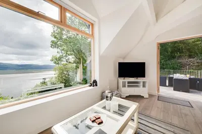 a living room with a large window and a tv at 2 Bed in Aberdyfi oc-wah694 in Aberdyfi