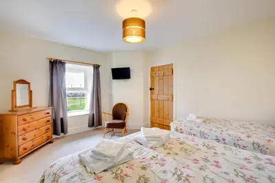 a bedroom with two beds and a dresser and a window at 2 Bed in Barmouth oc-wah698 in Talybont
