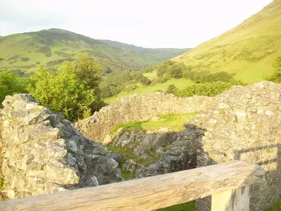 a view of a stone wall with mountains in the background at The Dolgoch in Bryn-crug