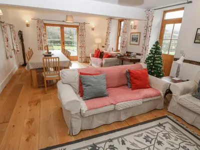 a living room with a couch and a christmas tree at Peniarth Ganol in Tywyn