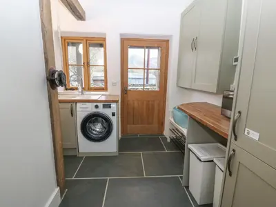 a kitchen with a washing machine and a washer at Peniarth Ganol in Tywyn
