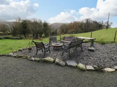 a group of benches sitting around a table and a picnic table at Peniarth Ganol in Tywyn