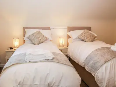 two beds sitting next to each other in a bedroom at Oakland Cottage in Craven Arms
