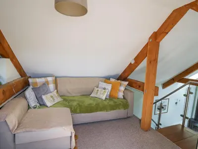 a couch with pillows on it in a attic at Yr Hen Beudy in Aberystwyth