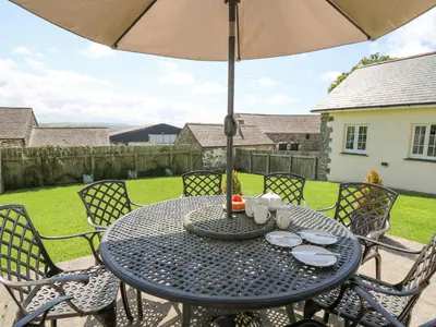 a table with an umbrella on a patio at Yr Hen Beudy in Aberystwyth