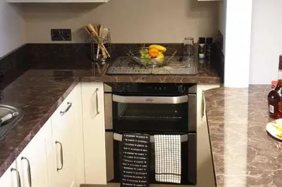 a kitchen with a black oven and a bowl of fruit at Seaview Apartment Sleeps 2 -Patio -WiFi -Tv in Barmouth